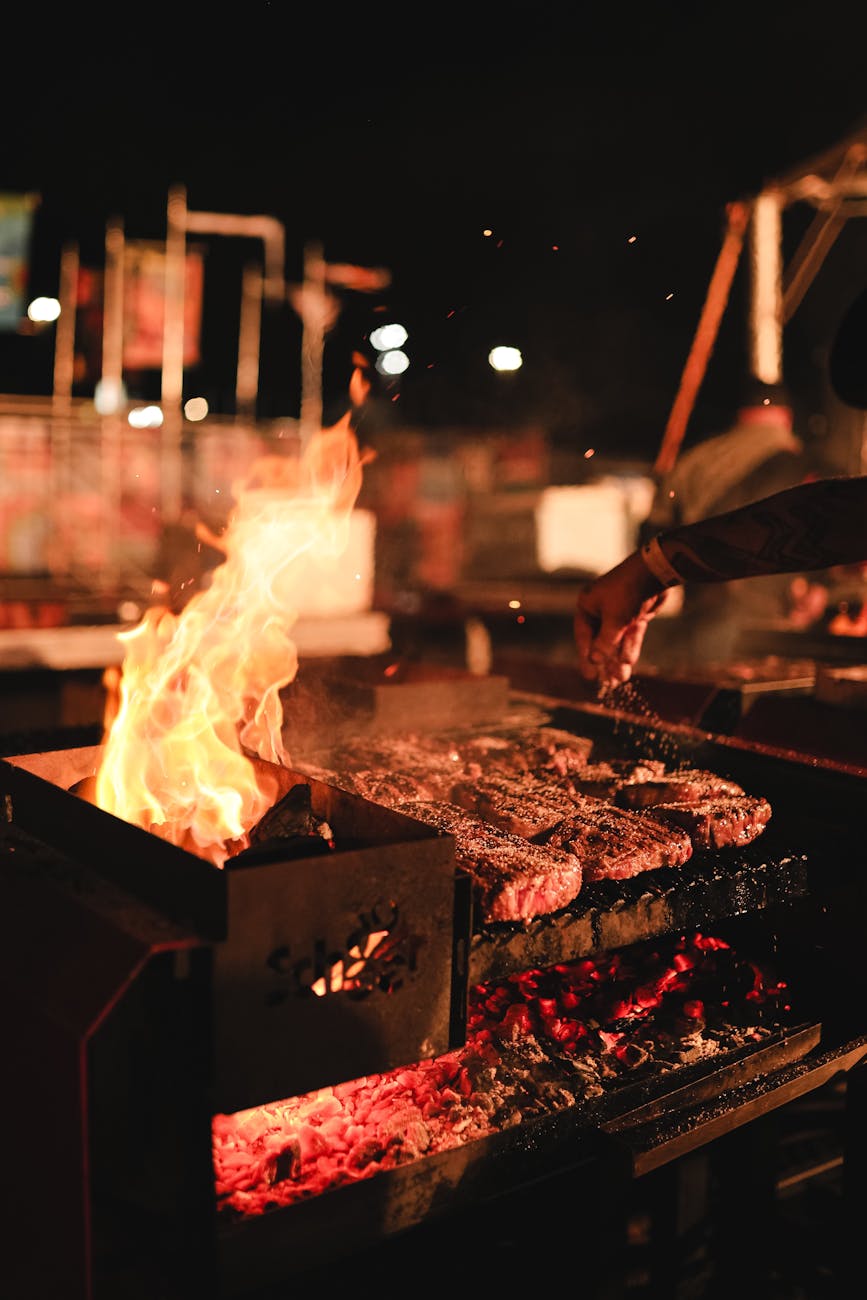 nighttime bbq with grilled meat and flames