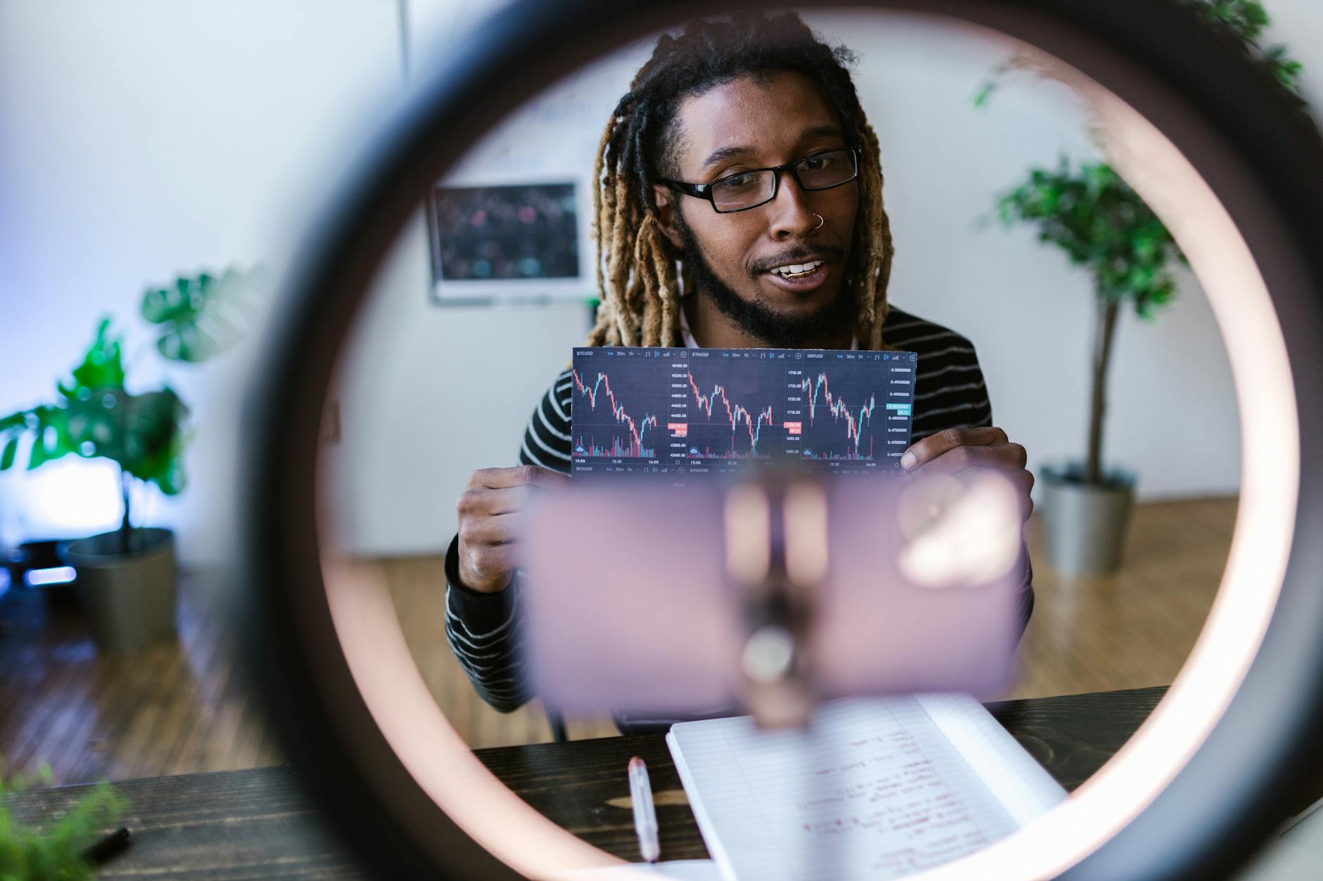 male vlogger holding a sheet of data analysis
